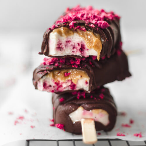 stack of chocolate ice cream bars with freeze dried raspberries on top.