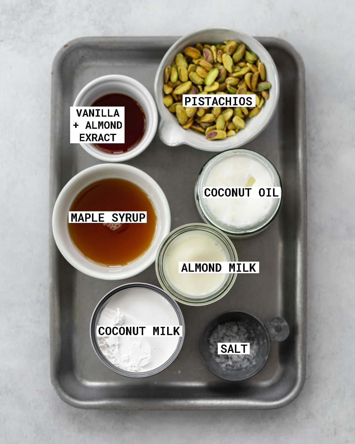 ingredients to make dairy free pistachio ice cream on a metal tray.