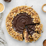 chocolate tart with peanuts on top and peanut butter in the centre.