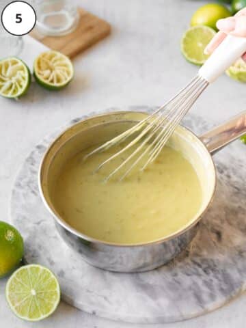 a saucepan with vegan key lime pie filling being stirred with a whisk.