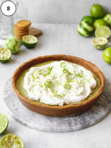 freshly set vegan key lime pie topped with dairy free whipped cream and lime zest.