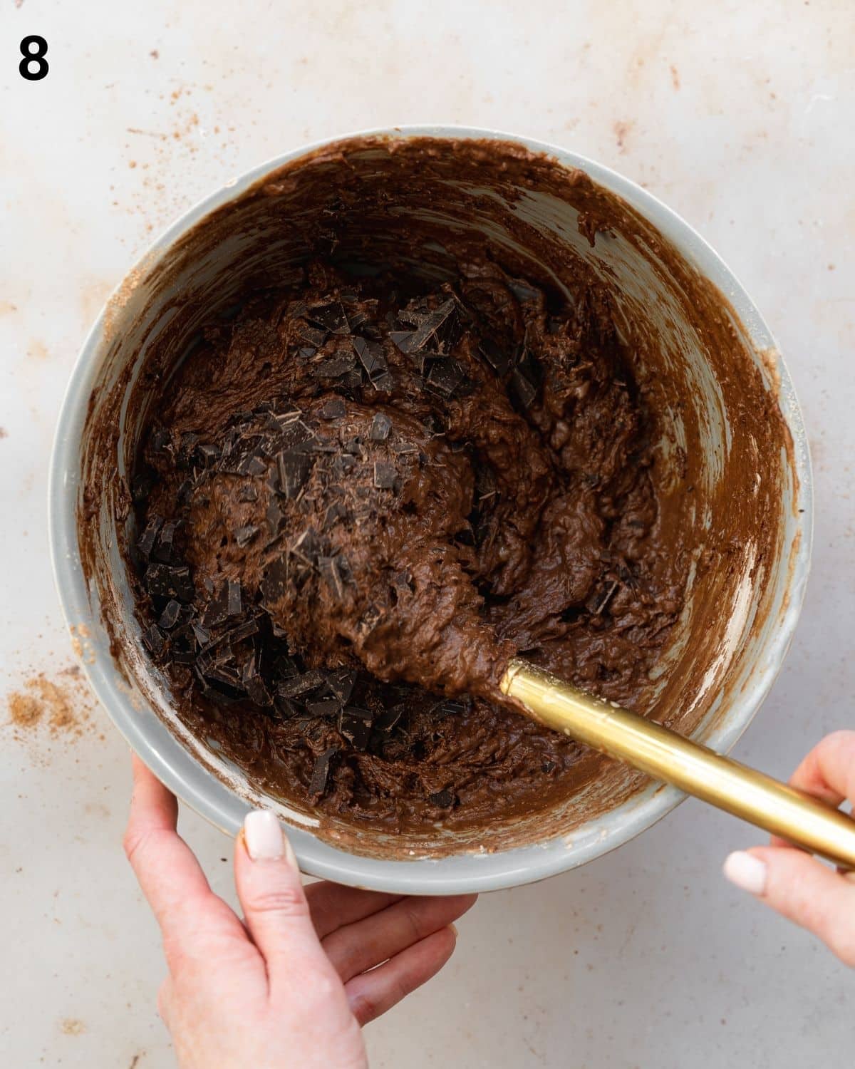 folding chocolate chips into brownie batter.