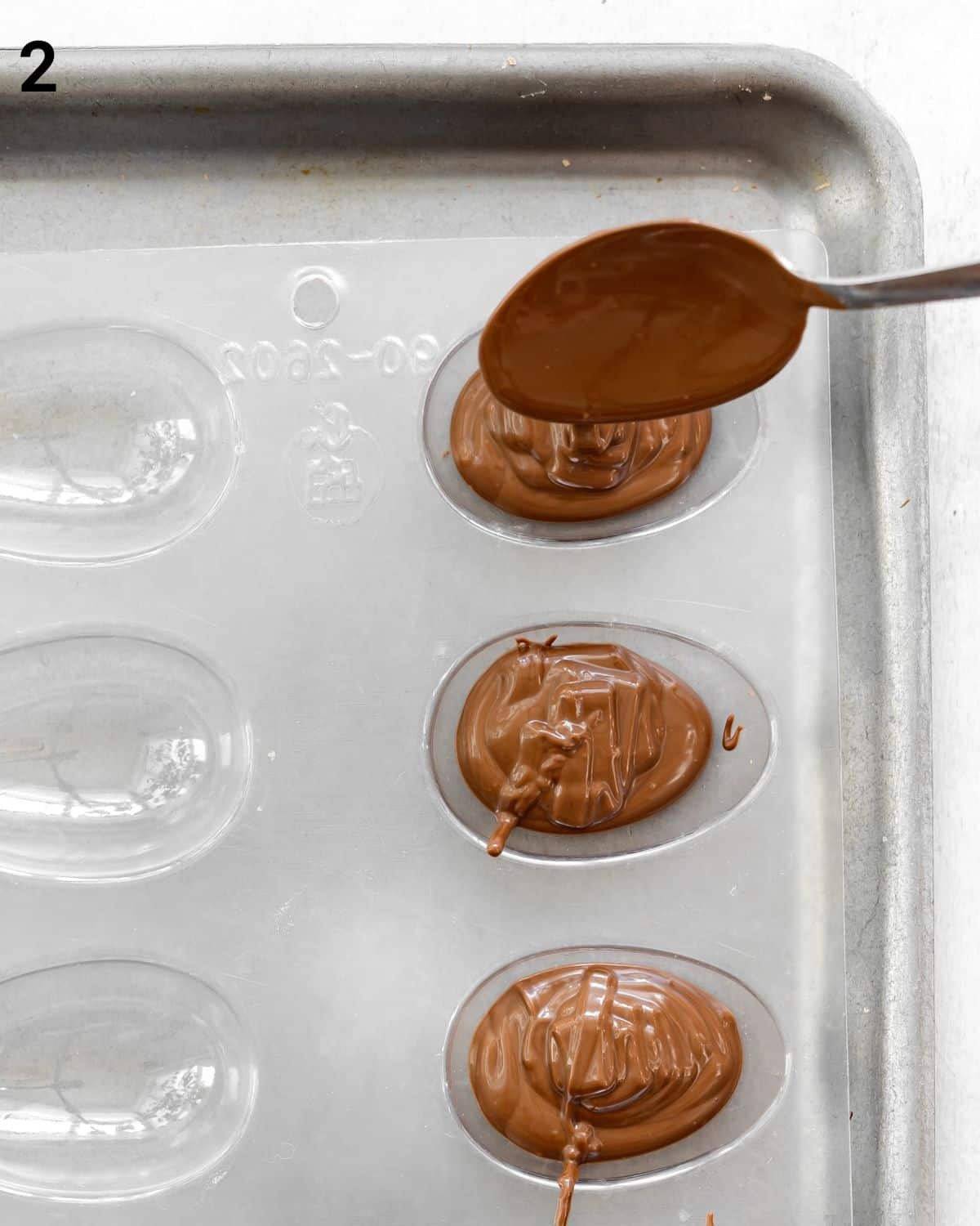 melted chocolate in easter egg molds.