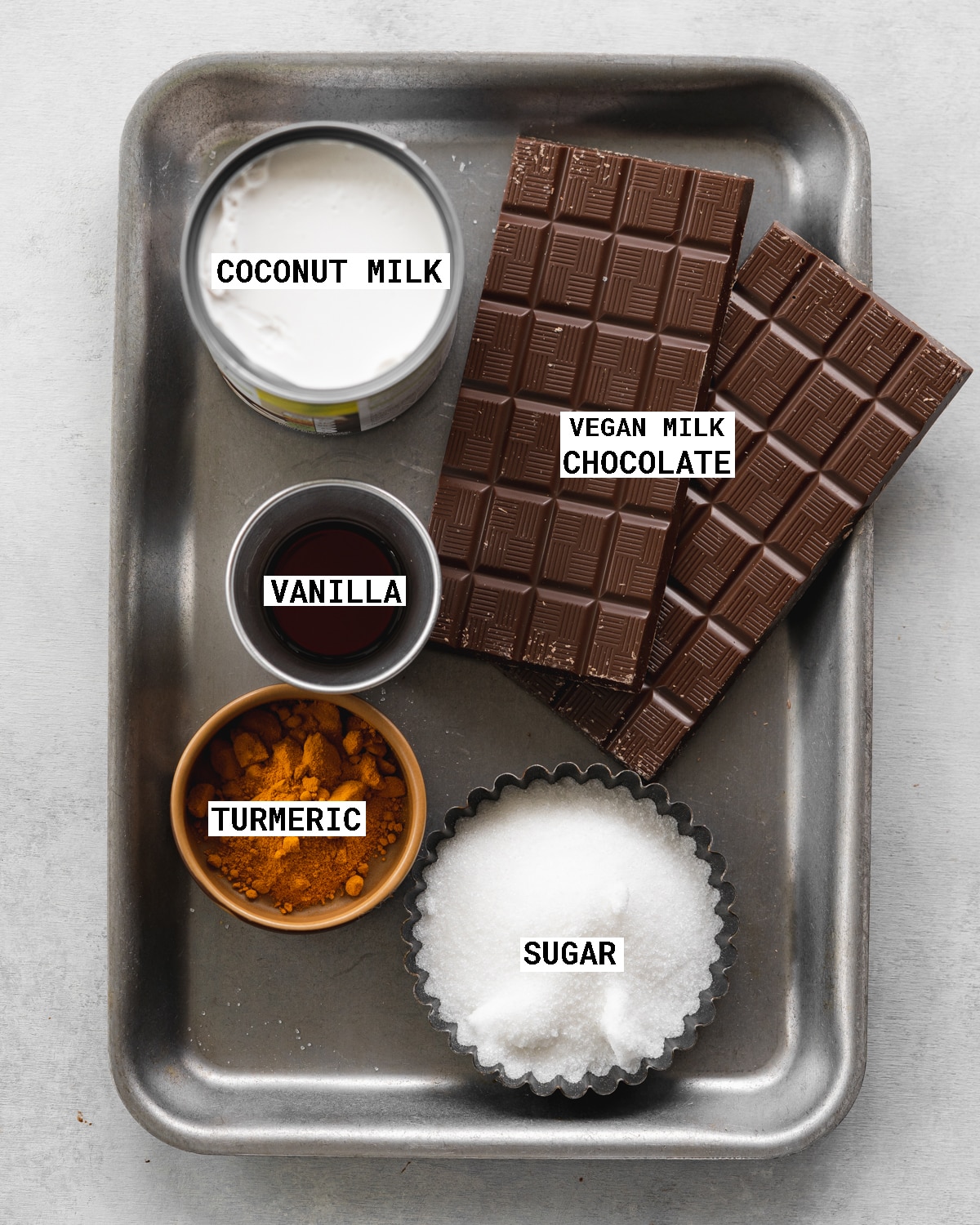 ingredients to make dairy-free giant creme egg on a metal tray.