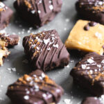 close up of chocolate covered caramel brownies on metal tray.