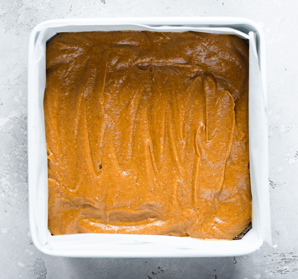 pumpkin caramel sauce on top of an oaty base in a pan.