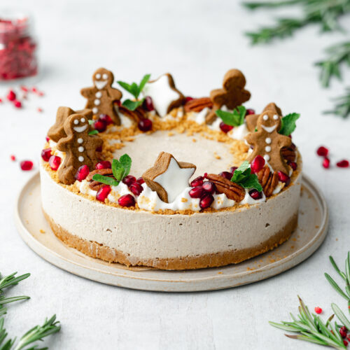 Christmas cheesecake on a plate with gingerbread men on top.
