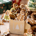 gingerbread cookies in a gift box with christmas decorations around it.