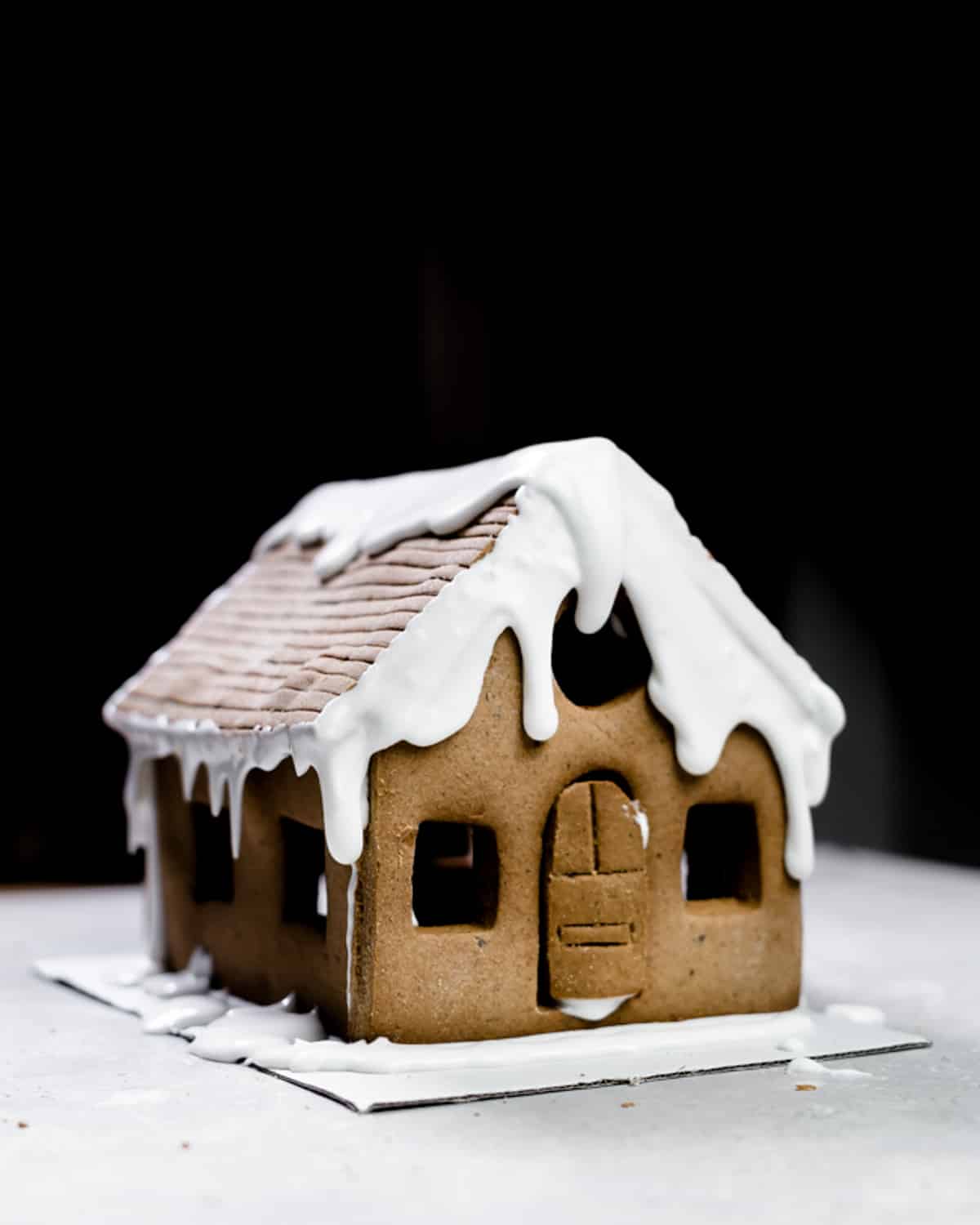 vegan gingerbread house with royal icing snow on top