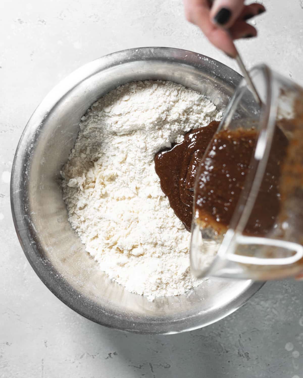 pouring wet ingredients into bowl of dry flour.