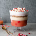layered trifle in a large glass bowl against dark grey background.