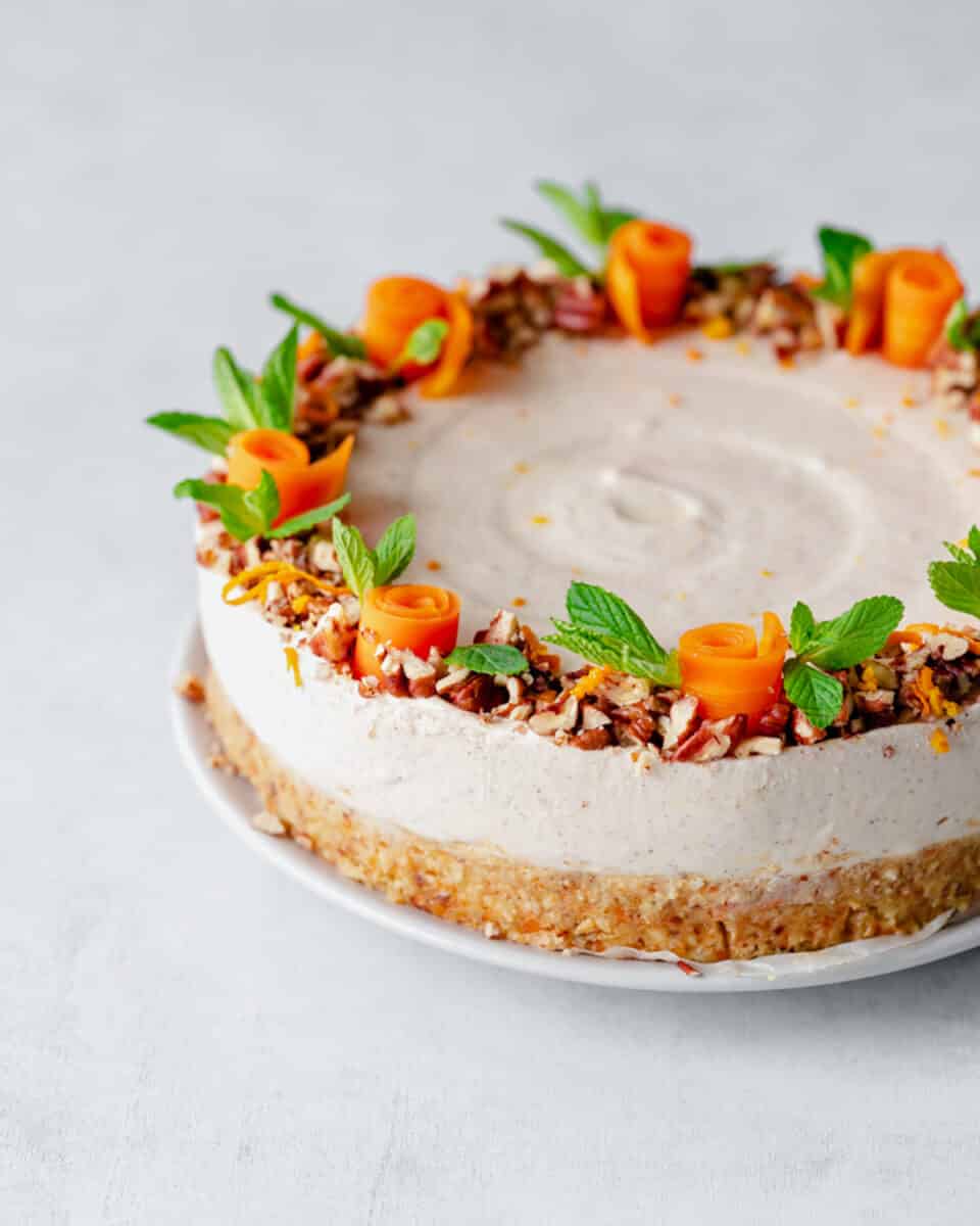 carrot cake cheesecake with mint leaves and candied carrots on top.