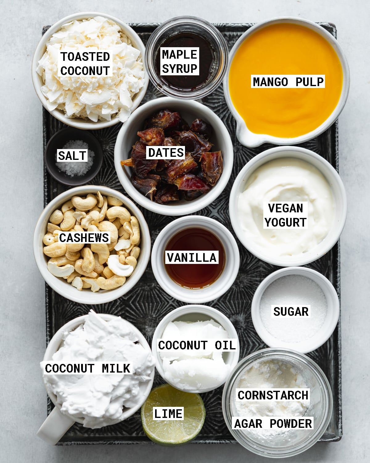 top down view of a metal tray with ingredients for making mango cheesecake.