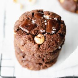 stack of double chocolate cookies on cooling rack with salt flakes.