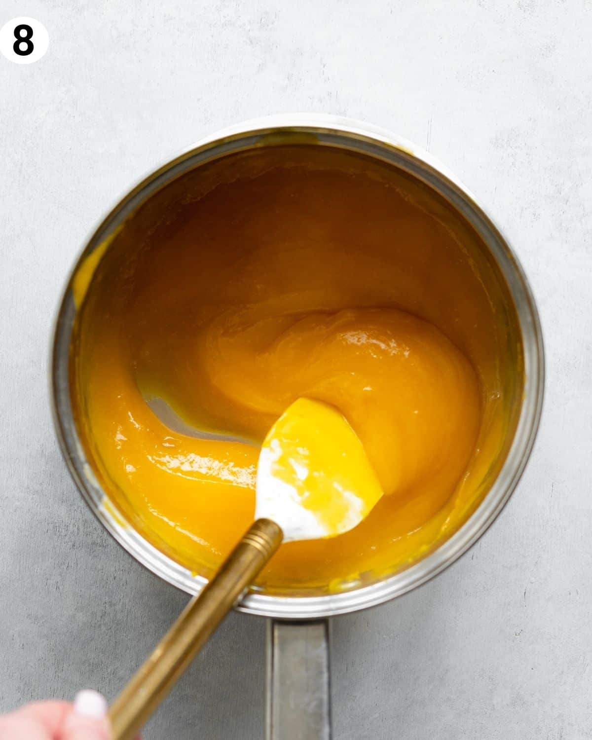 top down view of saucepan with mango curd.