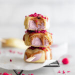 stack of white chocolate raspberry ice cream bars on cooling rack with almond butter drizzle.