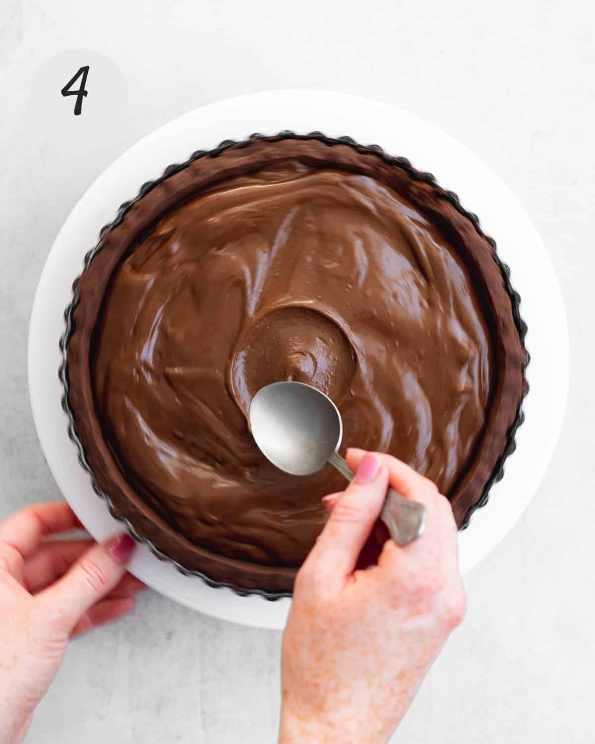 spooing chocolate ganache into tart shell.