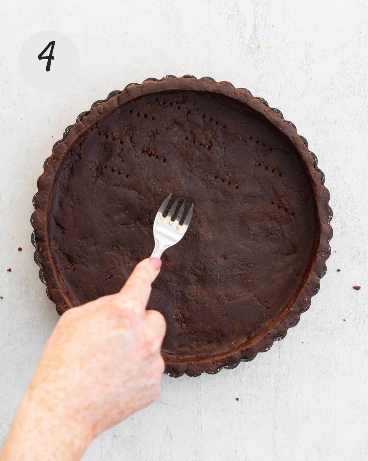 piercing holes into shortbread crust with fork.