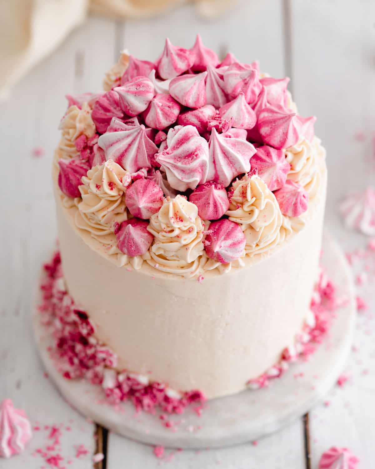 vegan cake with champagne buttercream and pink meringue kisses.