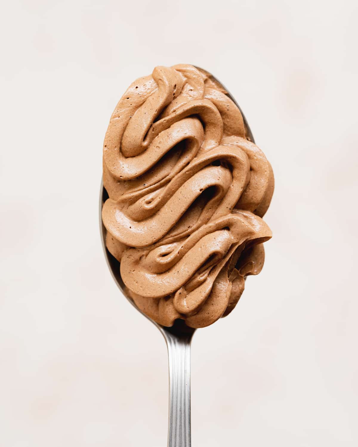 chocolate buttercream piped on a spoon.
