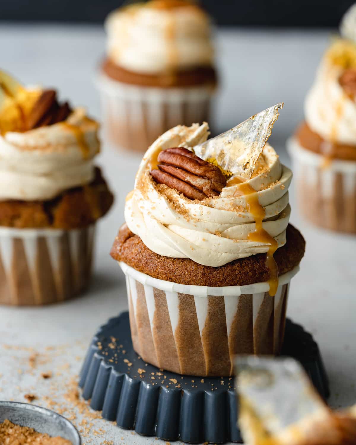 caramel cupcakes topped with pecans and caramel shards.