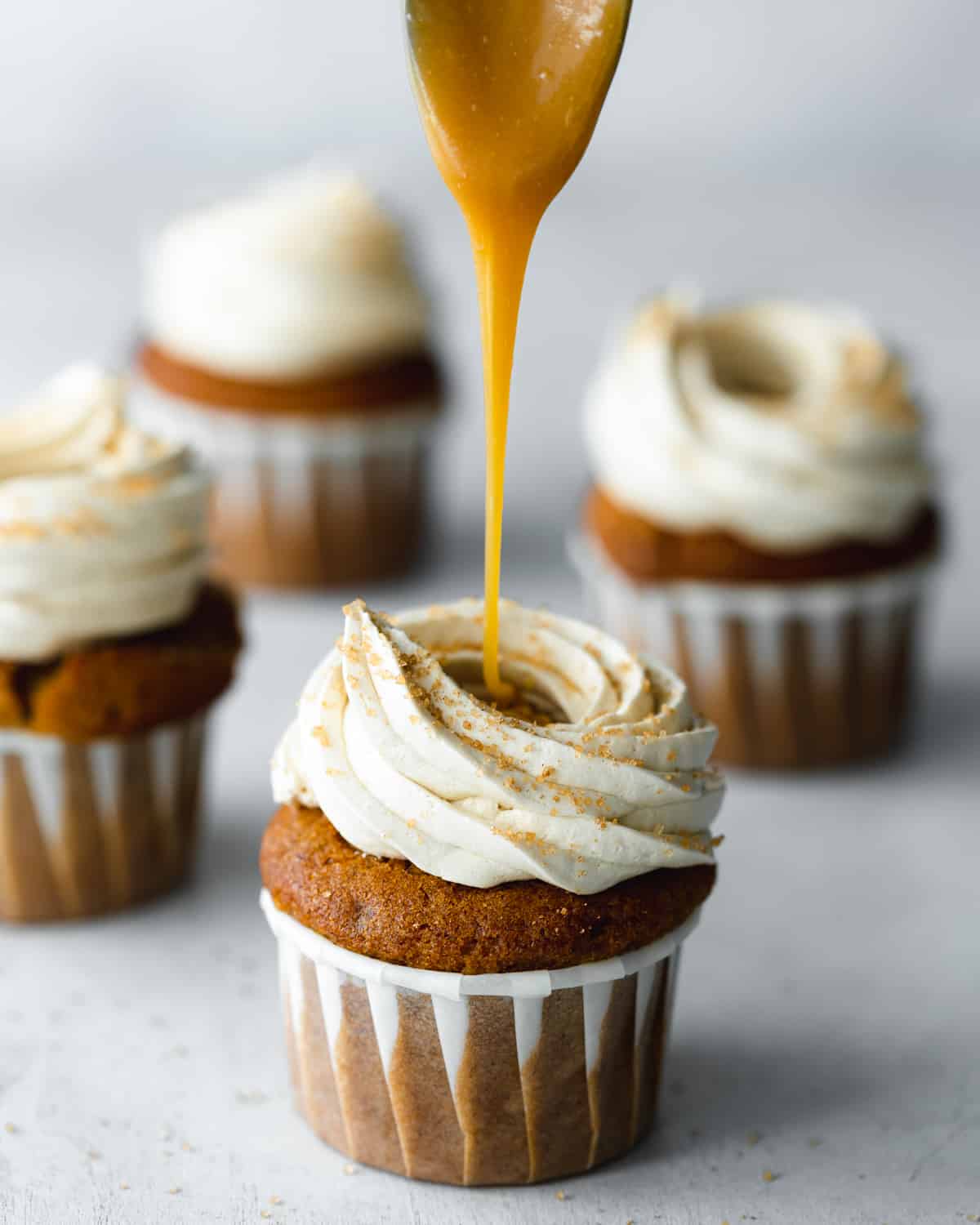 cupcakes being filled with caramel sauce.