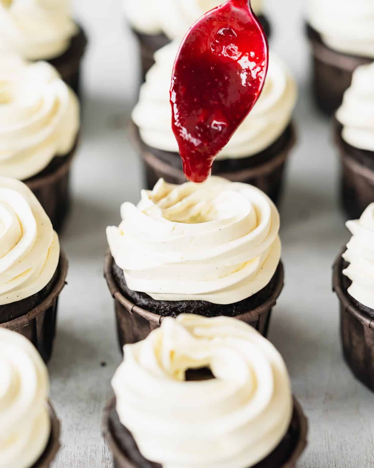 adding cherry filling to chocolate cupcakes.