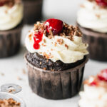 chocolate cupcakes with cherry on top and white buttercream.