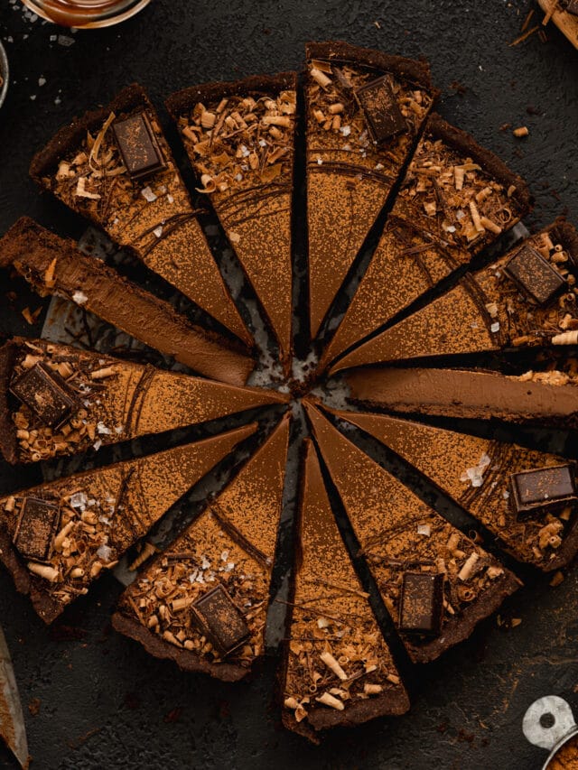 chocolate tart sliced on a dark background.