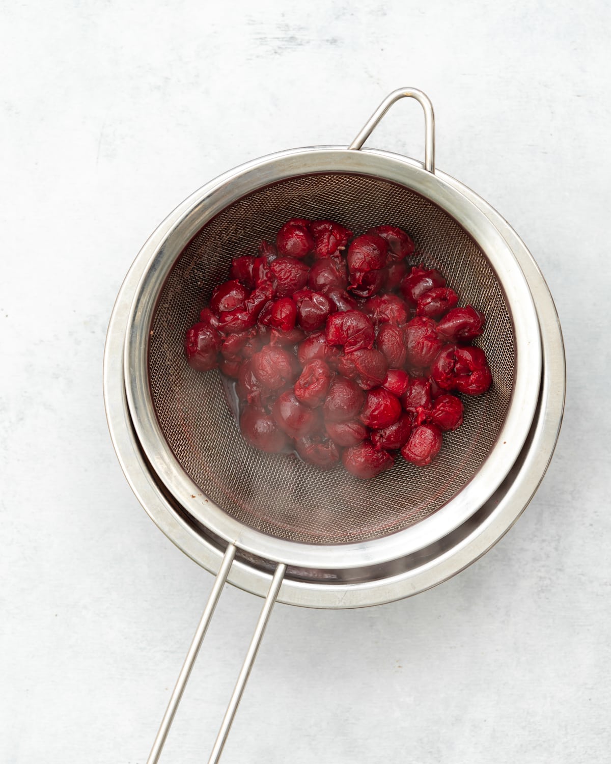 cherries in a fine mesh sieve.