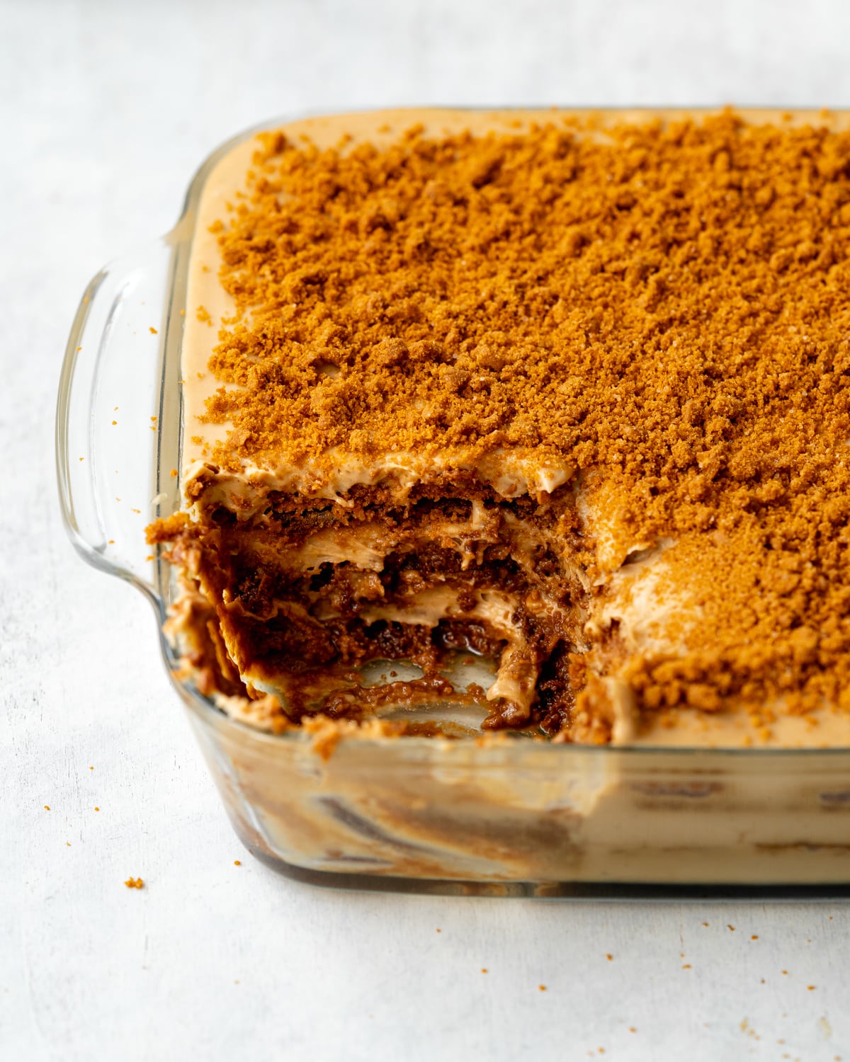 speculoos tiramisu with lotus cookies in a glass baking dish.