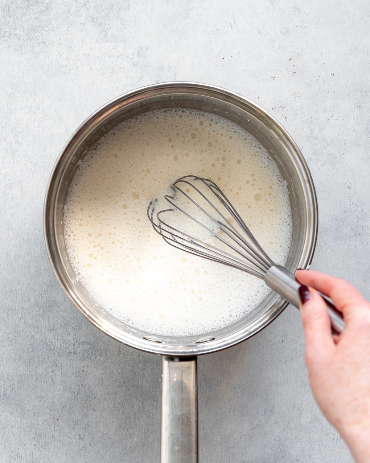 whisking custard in a saucepan.