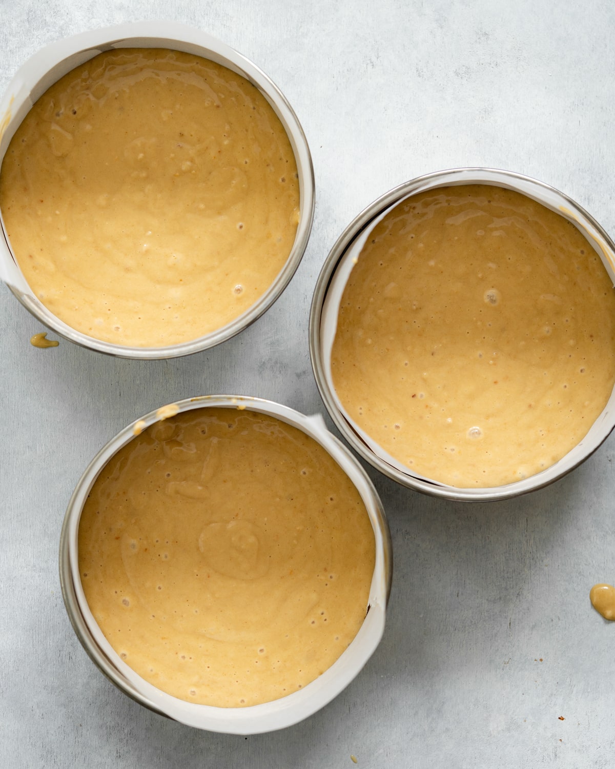 hazelnut vanilla cake batter in 3 cake pans.
