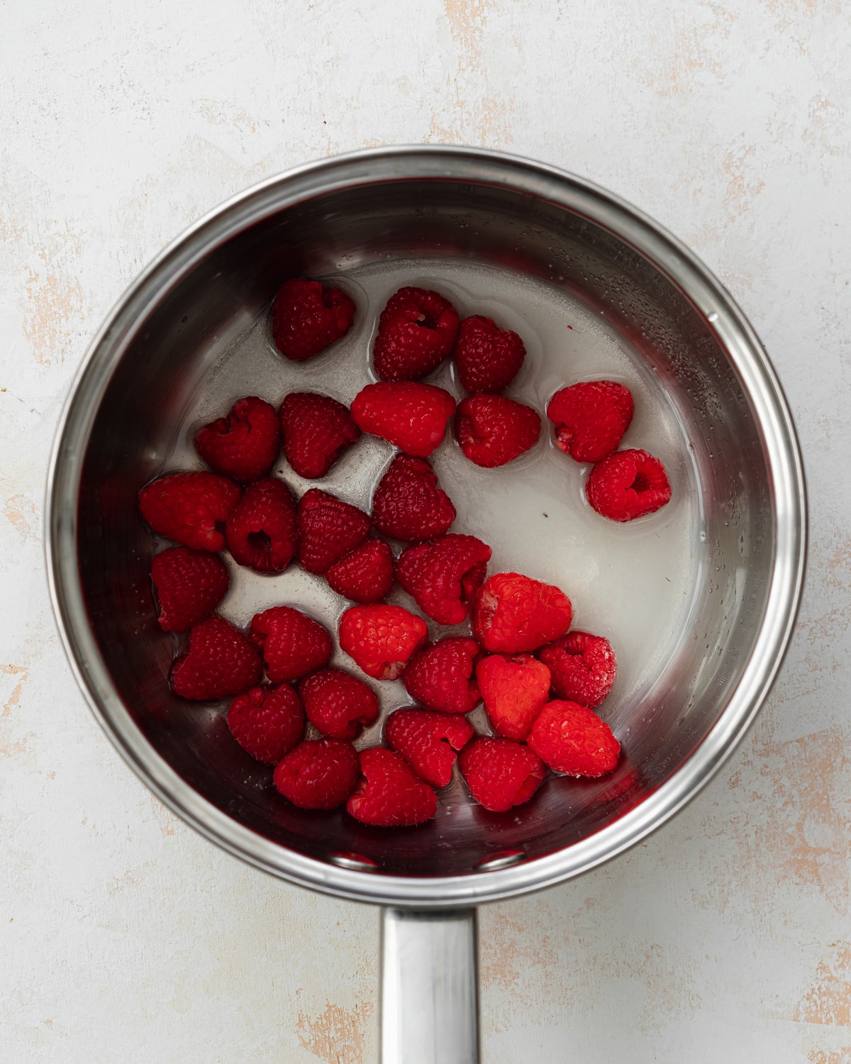 fresh raspberries and sugar in a saucepan.