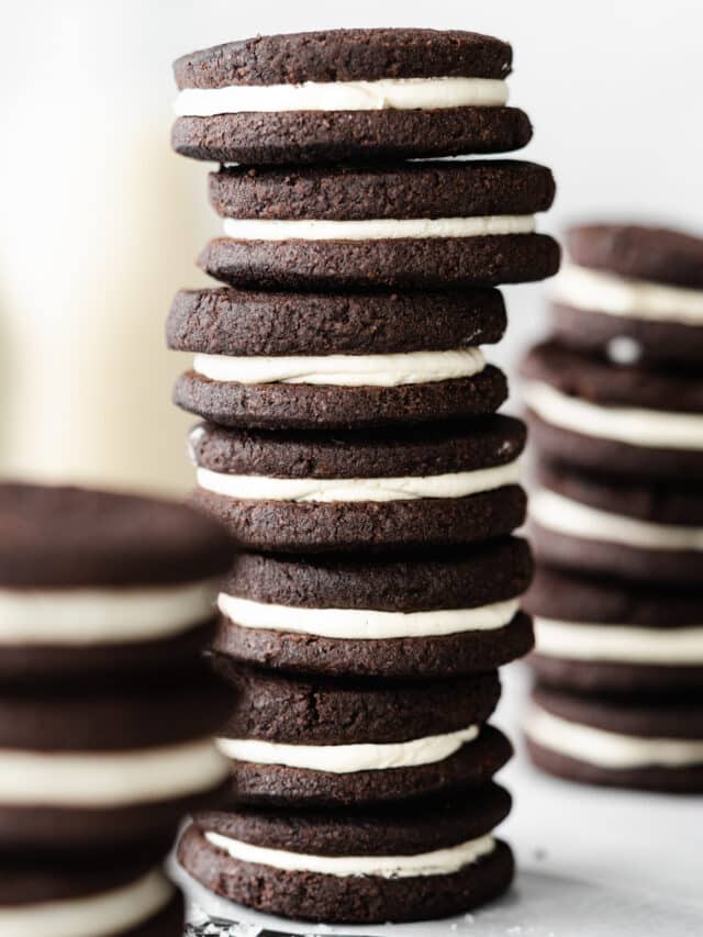 stacks of vegan oreos with milk bottles in the background.