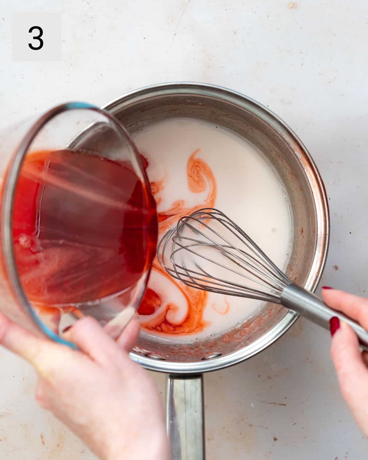 pouring strawberry reduction into a saucepan with cornflour mixture.