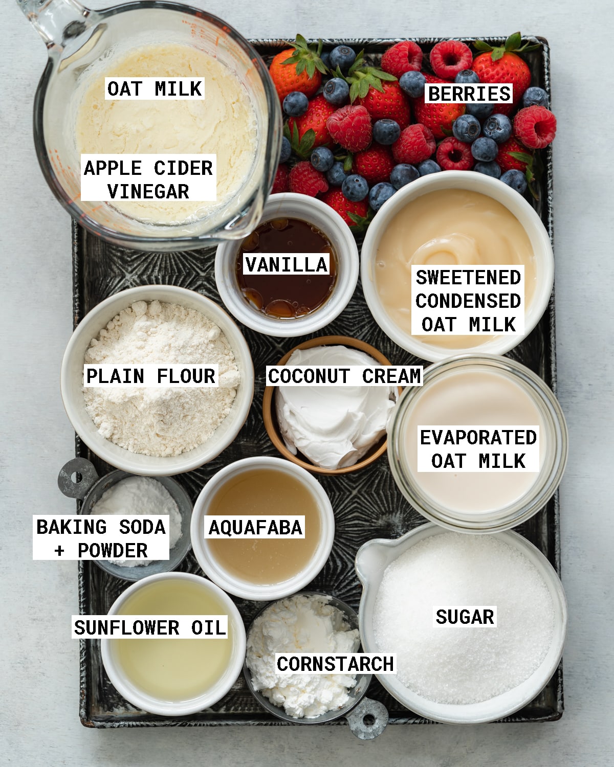 top down view of ingredients to make vegan tres leches cake on a metal tray.
