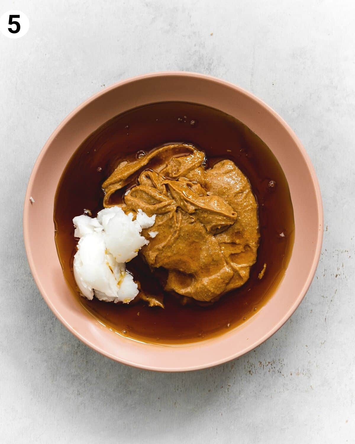 top down view of ingredients for peanut butter caramel in a pink bowl.