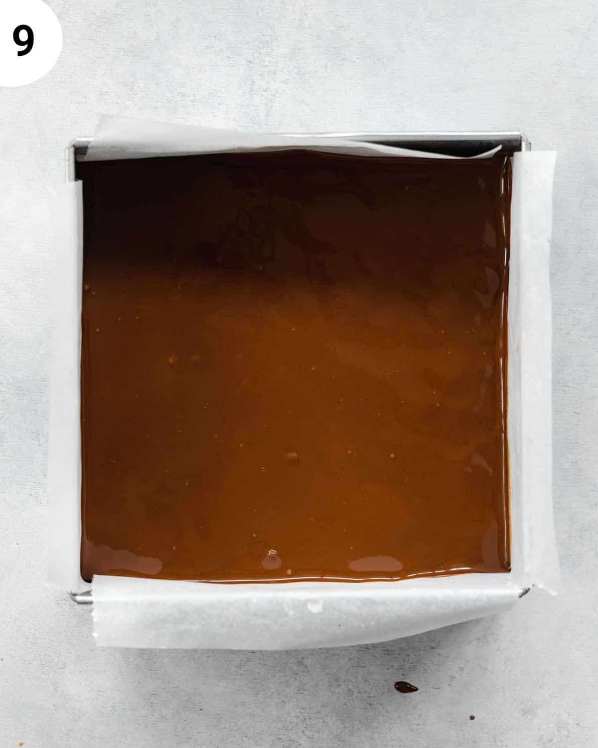 top down view of chocolate covered brownies in a metal cake tin.