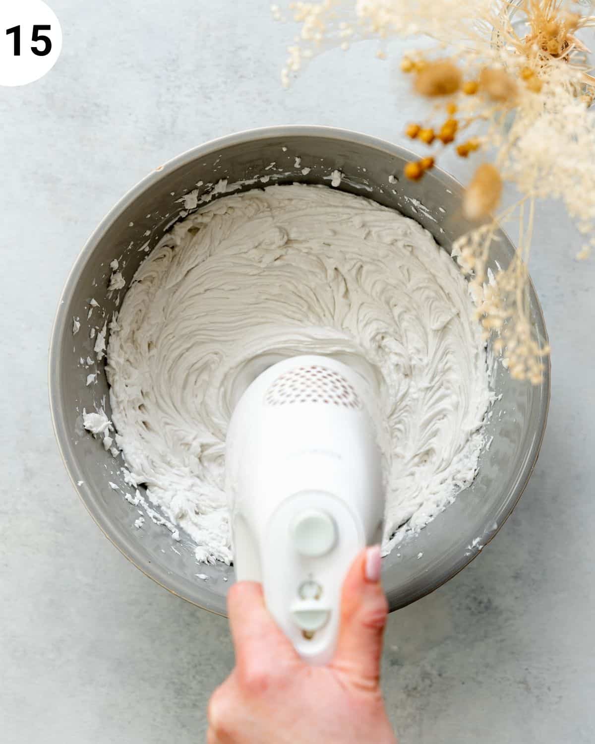 top down view of coconut cream being whisked in a bowl.