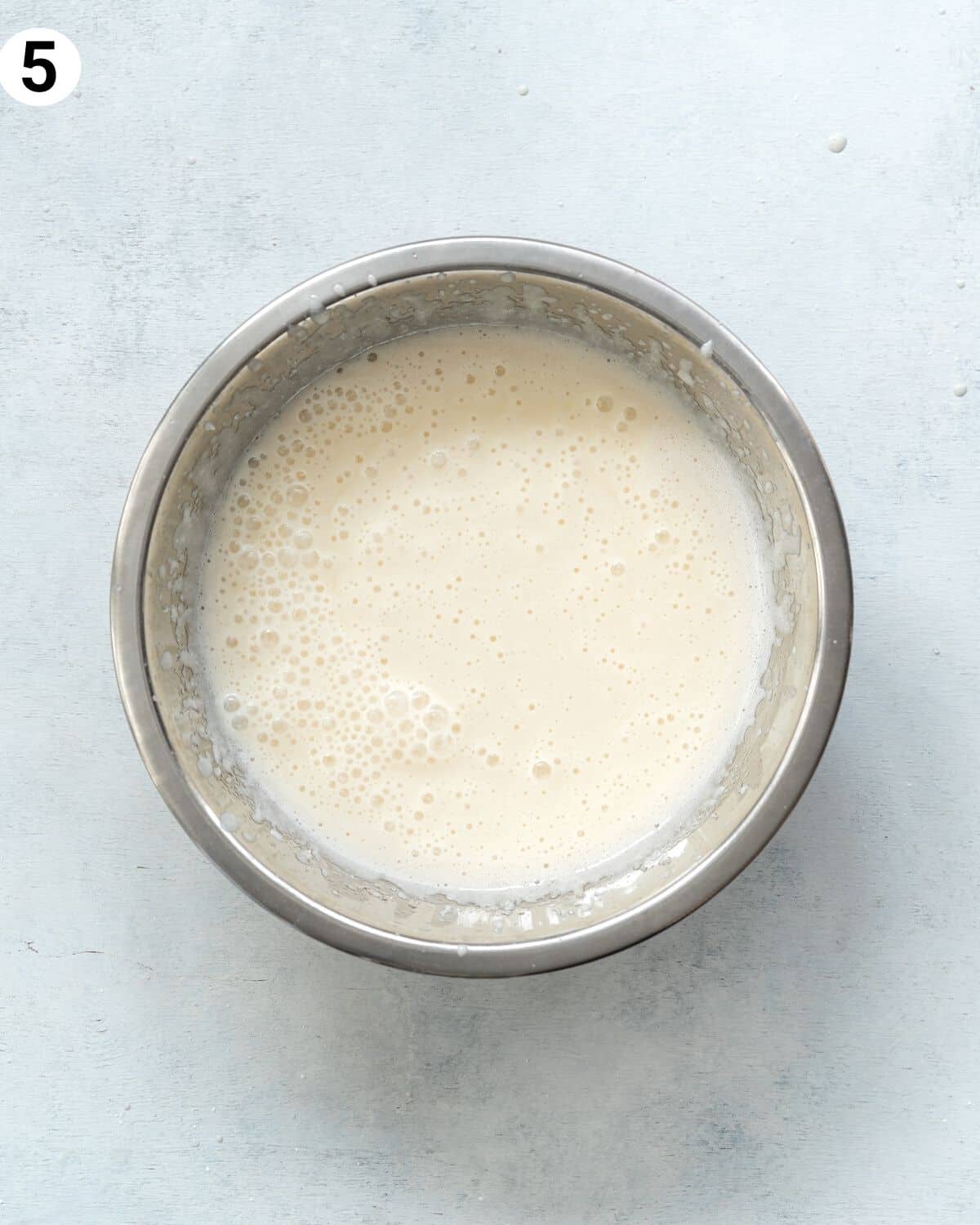 top down view of wet ingredients for tres leches cake in a bowl.