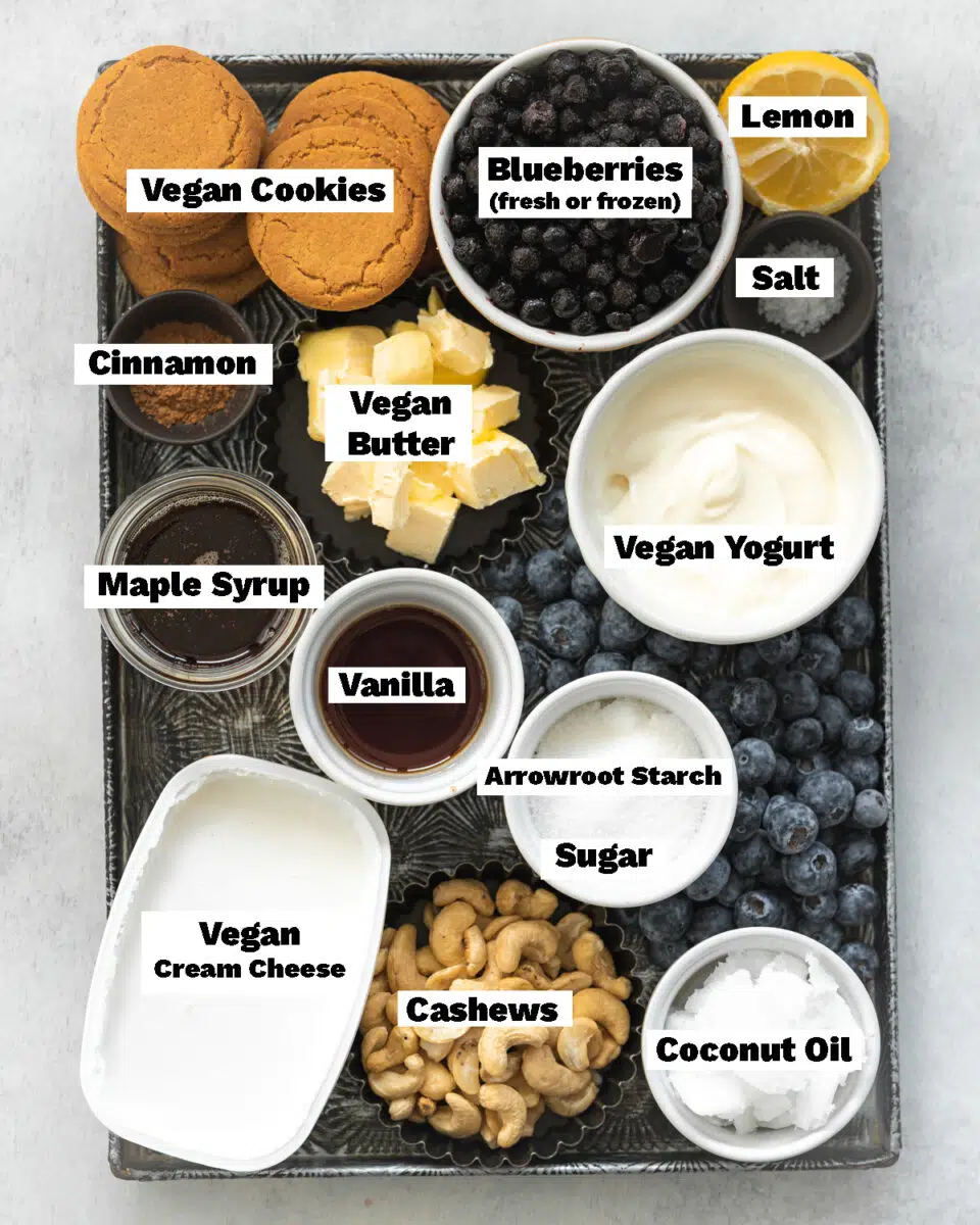 top down view of ingredients for blueberry cheesecake measured out on a metal tray.