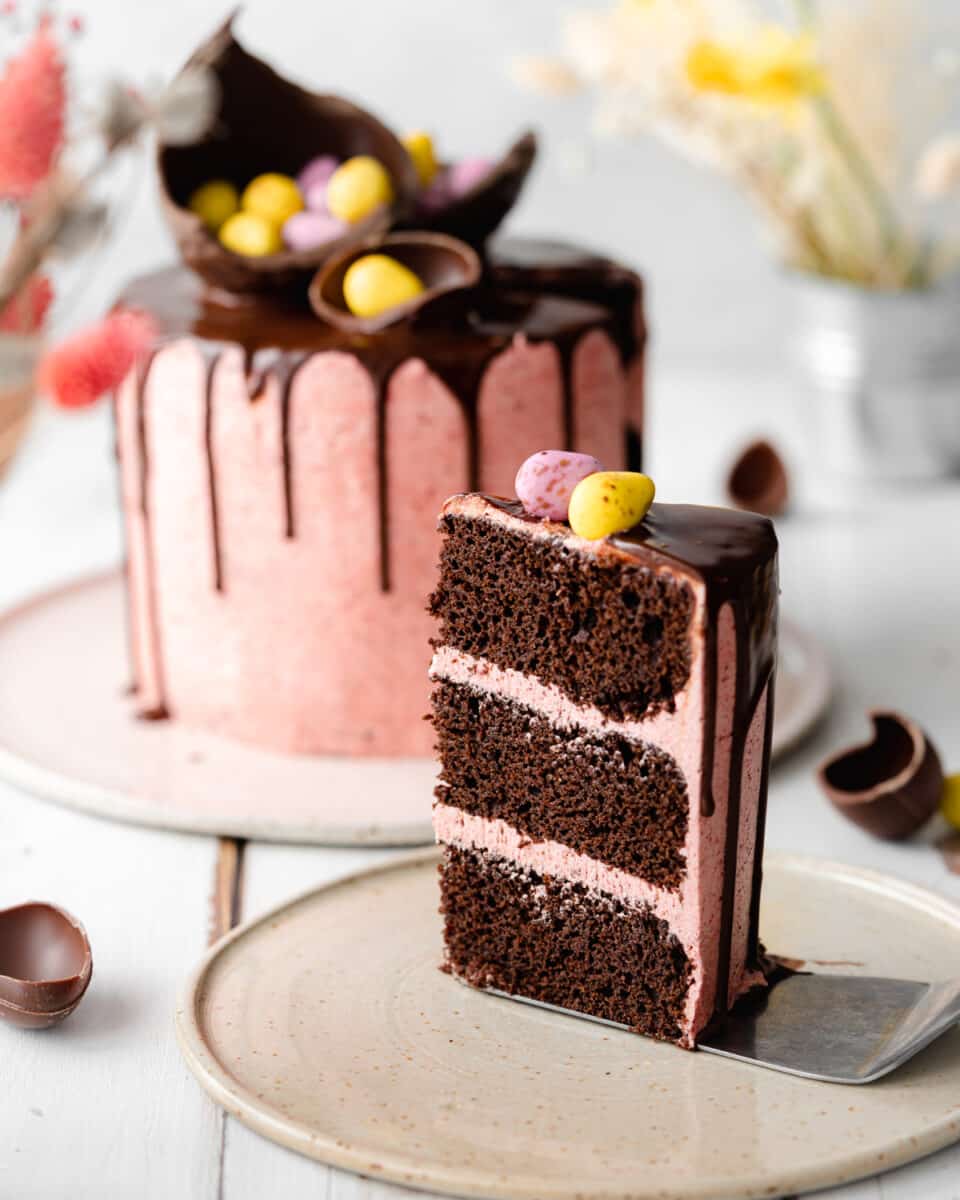 slice of chocolate and strawberry layered cake with mini easter eggs on top.