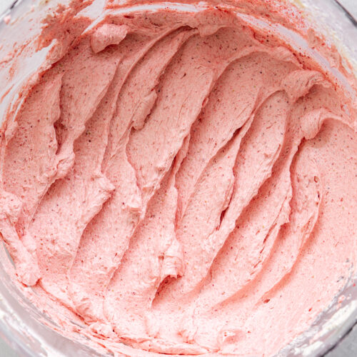 top down view of strawberry buttercream in a clear bowl.