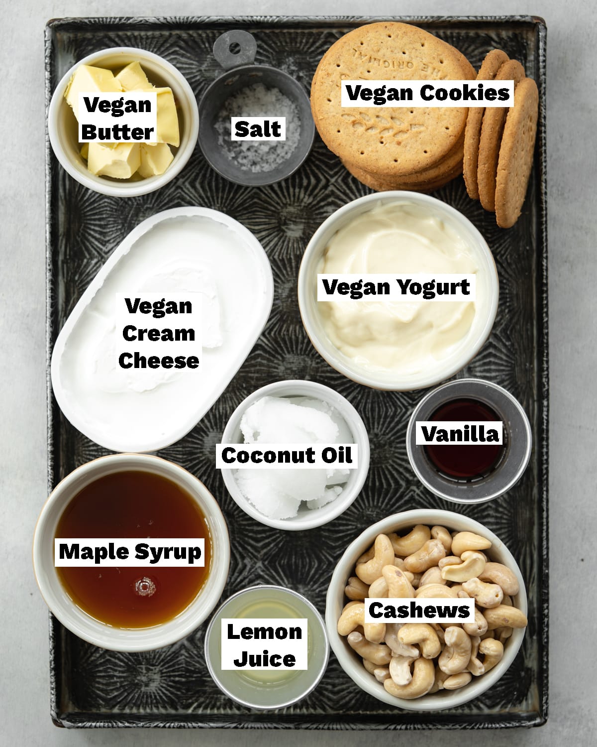 ingredients to make no bake cheesecake measured out on a vintage metal tray.