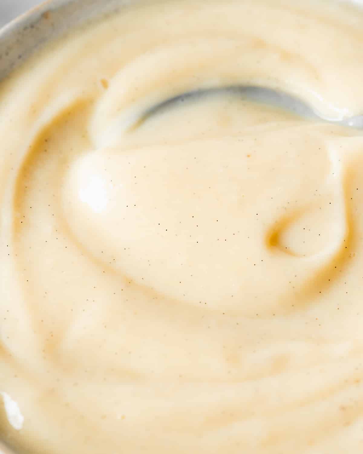 smooth vegan custard with vanilla specs in a bowl.