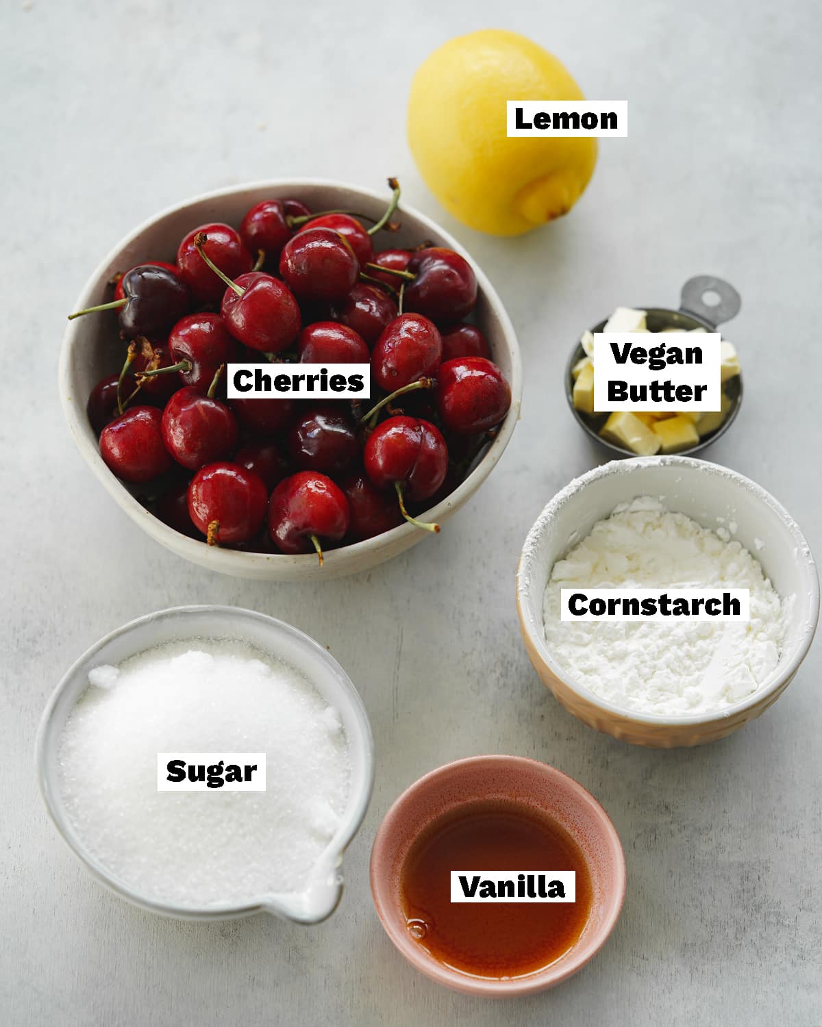 ingredients to make vegan cherry pie measured out on a grey surface.