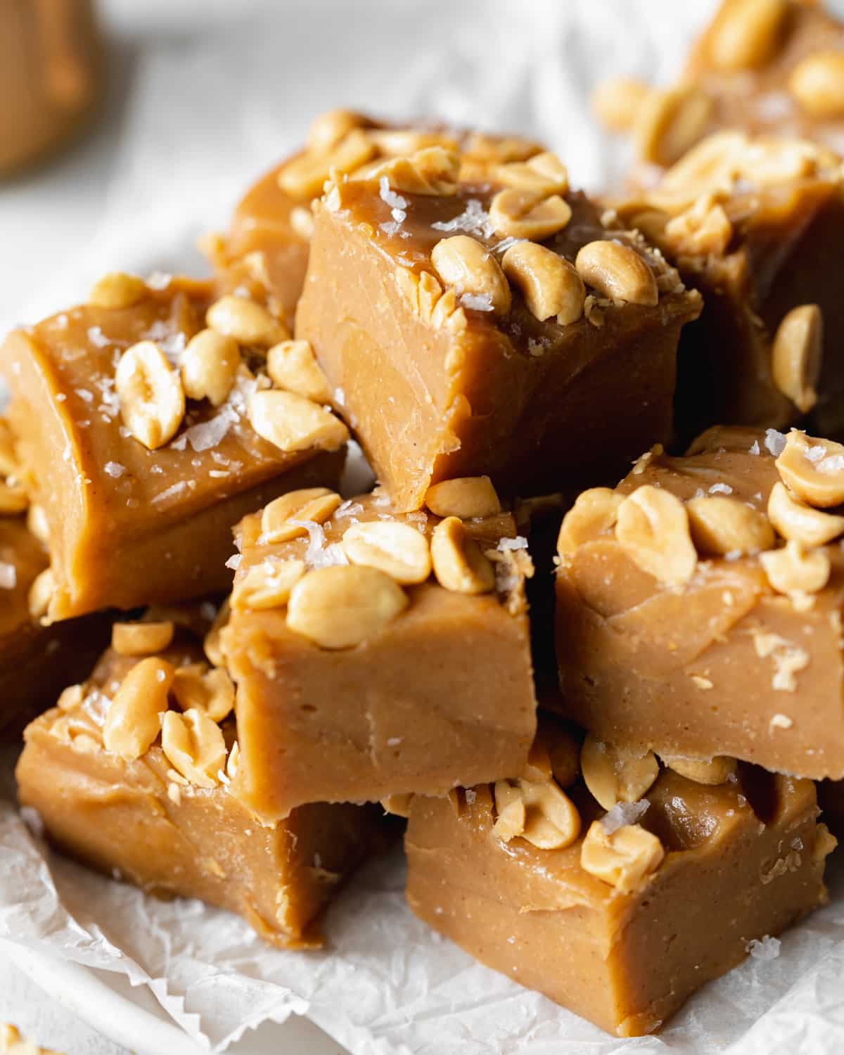 stack of peanut butter fudge on a plate with parchment paper.
