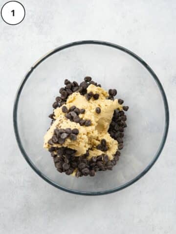 cookie dough in a large mixing bowl with chocolate chips added in.