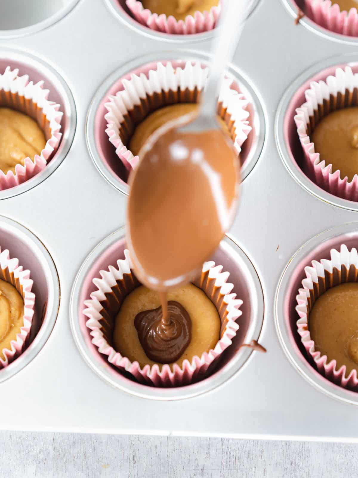 drizzling melted chocolate on top of the peanut butter layer in peanut butter cups.